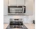 Modern kitchen featuring stainless steel appliances, white subway tile backsplash, and gray cabinets at 4441 N Meade St, Denver, CO 80211