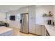 Modern kitchen with stainless steel appliances, light wood floors, white subway tiles, and gray cabinets at 4441 N Meade St, Denver, CO 80211