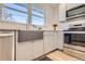 Modern kitchen with white cabinets, stainless steel appliances, and a farmhouse sink with a large window view at 4441 N Meade St, Denver, CO 80211