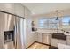 Bright kitchen featuring stainless steel refrigerator and appliances, gray cabinets, hardwood floors, and breakfast bar at 4441 N Meade St, Denver, CO 80211