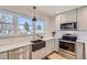 Beautiful kitchen featuring a stainless steel dishwasher, farmhouse sink, white subway tile, and stainless steel appliances at 4441 N Meade St, Denver, CO 80211