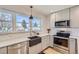 Well-lit kitchen featuring stainless appliances, modern cabinetry, and a farmhouse sink for a touch of charm at 4441 N Meade St, Denver, CO 80211