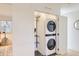 Convenient laundry area with stacked washer and dryer, shelving, and closet for organized living at 4441 N Meade St, Denver, CO 80211