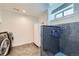 Modern laundry room with dog washing station, stainless steel washer/dryer, and gray hexagon tile flooring at 4441 N Meade St, Denver, CO 80211