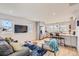Bright, open-concept living area with hardwood floors, large TV, and a modern kitchen at 4441 N Meade St, Denver, CO 80211