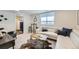 Bright living room with a leather sectional, a hide rug, and a view into the kitchen area at 4441 N Meade St, Denver, CO 80211