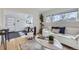 Bright living room with hardwood floors, modern furniture, large windows, and view into entry at 4441 N Meade St, Denver, CO 80211