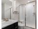 Bathroom featuring a tiled shower with glass door and vanity with marble countertop at 5072 Lake Port Ave, Firestone, CO 80504