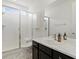 Bright bathroom featuring a large, tiled shower with glass door and vanity with marble countertop at 5072 Lake Port Ave, Firestone, CO 80504