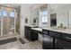 A bright bathroom features double sinks, vanity, glass shower, and walk-in closet at 5072 Lake Port Ave, Firestone, CO 80504