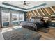 A stylish bedroom with wood accent wall, ceiling fan, and large windows at 5072 Lake Port Ave, Firestone, CO 80504