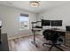 Bedroom features a wood floor, modern ceiling fan, and a large window that lets in plenty of natural light at 5072 Lake Port Ave, Firestone, CO 80504