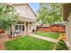Backyard with a covered porch, green grass, and a wood fence at 3864 Osceola St, Denver, CO 80212