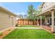 Landscaped backyard featuring grass, wood fence, detached garage, and covered deck with outdoor seating area at 3864 Osceola St, Denver, CO 80212
