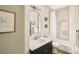 Bright bathroom with a modern vanity, round mirror, and a tub and shower combination behind a white shower curtain at 3864 Osceola St, Denver, CO 80212
