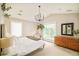 Relaxing bedroom with large windows, a modern chandelier, neutral décor, and light-colored walls and carpeting at 3864 Osceola St, Denver, CO 80212