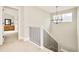 Bright hallway featuring a decorative chandelier, railing with black bars, and a glimpse into a room with a wooden dresser at 3864 Osceola St, Denver, CO 80212