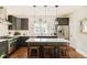 Modern kitchen with stainless steel appliances, a center island with seating, and elegant lighting at 3864 Osceola St, Denver, CO 80212