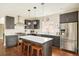 Kitchen boasts stainless steel appliances, dark wood cabinets, a center island, and hardwood floors at 3864 Osceola St, Denver, CO 80212