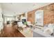 Bright living room featuring exposed brick wall, fireplace, and hardwood floors at 3864 Osceola St, Denver, CO 80212