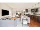 Open-concept living area leads to a kitchen with bar seating, dining area, and a brick fireplace at 3864 Osceola St, Denver, CO 80212