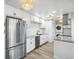 Bright kitchen with white cabinetry, granite countertops, stainless steel appliances, and stacked washer and dryer at 7995 E Mississippi Ave # A4, Denver, CO 80247