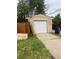 Exterior view of garage with white door, concrete driveway, and surrounding trees at 1900 Quebec St, Denver, CO 80220