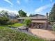 Home exterior features a cozy backyard patio with stone landscaping and lush grass at 14418 W Bayaud Ave, Golden, CO 80401