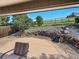 Covered backyard patio features a stone patio with waterfall feature and comfortable seating area at 14418 W Bayaud Ave, Golden, CO 80401