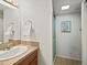 Bathroom features a white single sink vanity, granite countertop and tiled shower with glass doors at 14418 W Bayaud Ave, Golden, CO 80401