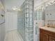 Bright bathroom featuring glass block partition, neutral marble countertop, and decorative mirror at 14418 W Bayaud Ave, Golden, CO 80401