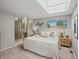 Bright main bedroom featuring a skylight and ensuite bathroom with glass block accents at 14418 W Bayaud Ave, Golden, CO 80401