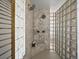 Luxurious shower with double shower heads, marble walls, and glass block partition at 14418 W Bayaud Ave, Golden, CO 80401