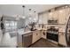Modern kitchen featuring stainless steel appliances and a sleek design, open to the living area at 1831 S Dunkirk St # 103, Aurora, CO 80017