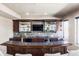 Basement bar with granite countertop, dark wood cabinets, and a flat screen TV at 6918 S Riverwood Way, Aurora, CO 80016