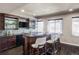 Basement bar with granite countertop, dark wood cabinets, and seating for three at 6918 S Riverwood Way, Aurora, CO 80016