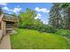 Large, well-maintained backyard with mature trees, lush grass, and an inviting patio area at 7077 Dudley Dr, Arvada, CO 80004