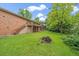 Expansive backyard featuring a well-maintained lawn, mature trees, and a brick house at 7077 Dudley Dr, Arvada, CO 80004