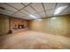 Basement showcasing a cozy fireplace, carpeted floors, and wood paneling at 7077 Dudley Dr, Arvada, CO 80004