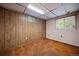 Basement featuring carpeted floors, wood paneling, and two windows at 7077 Dudley Dr, Arvada, CO 80004