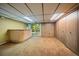 Basement featuring carpeted floors, wood paneling, a walkout door, and a built-in bar area at 7077 Dudley Dr, Arvada, CO 80004