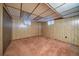 Basement featuring carpeted floors, wood paneling, and two windows at 7077 Dudley Dr, Arvada, CO 80004