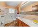 Well-lit bathroom featuring a shower-tub, peach walls, and a spacious vanity at 7077 Dudley Dr, Arvada, CO 80004