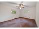 Bedroom with carpeted floors, white walls, two windows, and a ceiling fan with light at 7077 Dudley Dr, Arvada, CO 80004