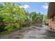 A spacious wooden deck with dark railings overlooks lush greenery under a bright blue sky at 7077 Dudley Dr, Arvada, CO 80004