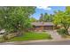 Charming brick ranch-style home with mature landscaping and lush green lawn in a serene neighborhood at 7077 Dudley Dr, Arvada, CO 80004