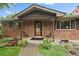 Inviting front porch with brick facade, decorative chairs, and stylish entryway at 7077 Dudley Dr, Arvada, CO 80004
