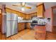 Traditional kitchen with stainless steel appliances, wood cabinets, hardwood floors, and a ceiling fan with light at 7077 Dudley Dr, Arvada, CO 80004