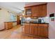 Classic kitchen featuring wood cabinets, black countertops, and a stainless steel refrigerator at 7077 Dudley Dr, Arvada, CO 80004