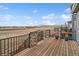 Wide angle view of a wood deck with dark metal railings, stone supports and a view of the plains at 15076 W 93Rd Ave, Arvada, CO 80007